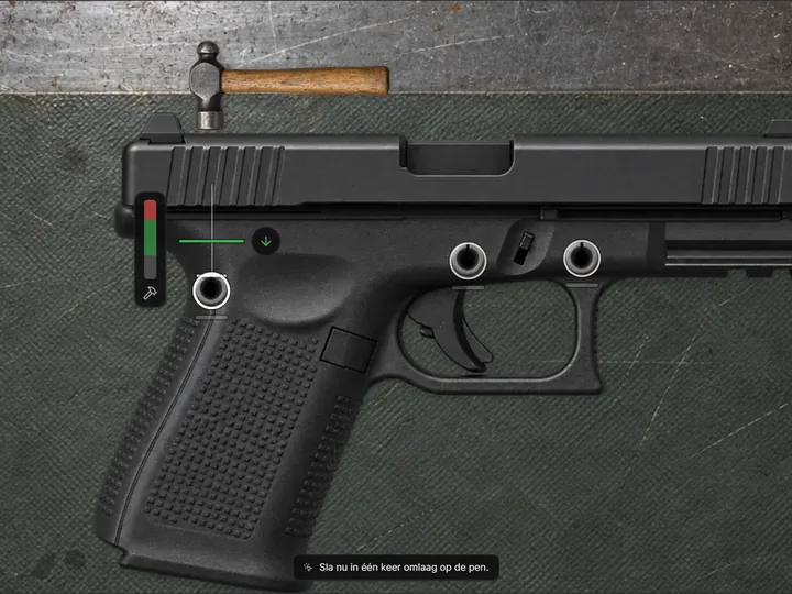 Hammer raised over a roll pin hole in a pistol frame with a strike meter