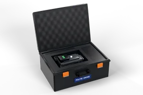 The police drone folded into the foam inlay of its open black case, with orange latches and a POLITIE DRONE label